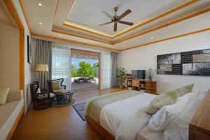 a bedroom with a large bed with a ceiling at Brennia Kottefaru Maldives in Raa Atoll