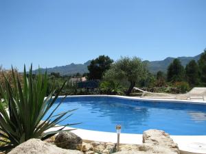 una piscina en una villa con montañas en el fondo en Casa Peregil, en Perelló