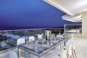 庫基尼坎尼奧的住宿－Villa Ada，一间设有玻璃桌和白色椅子的用餐室