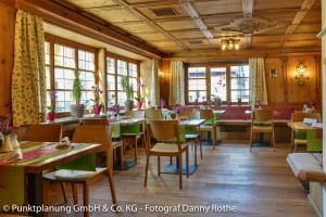 a restaurant with tables and chairs and windows at Das Schwanstein in Schwangau
