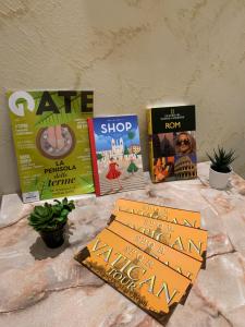 cuatro libros sentados en una mesa junto a una pared en B&B La Perla di Roma, en Roma