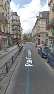 an empty city street with a blue line on the road at Rue François Miron in Paris