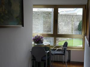 a dining room with a table and chairs and a window at Hotel España in Lugo