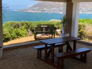 a wooden bench sitting in front of a beach at Simonsview in Simonʼs Town