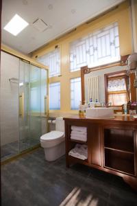 y baño con aseo, lavabo y ducha. en Beijing Jingyuan Courtyard Hotel, en Beijing