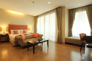 ein Hotelzimmer mit einem Bett, einem Sofa und einem Tisch in der Unterkunft Le Patta Hotel Chiang Rai SHA Extra Plus in Chiang Rai