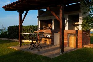 a patio with a table and chairs and a fireplace at 4Elies apartments in Vourvourou