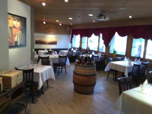 a restaurant with tables and chairs and a barrel in the middle at Motelina in Wattwil