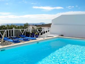 a swimming pool with blue water and chairs next to a building at VILLA DE LA VISTA in Playa Blanca