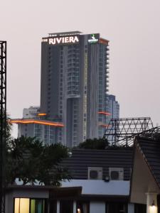 a tall building with a sign on it in a city at The Riviera Wongamat Hong Apartment in Pattaya North