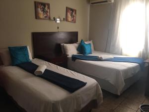 a hotel room with two beds and a window at Marys BnB in Mogwase