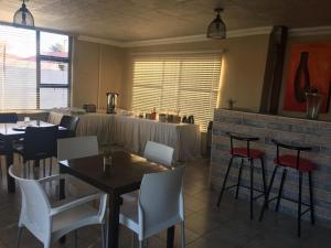 a restaurant with white chairs and tables and a table with a counter at Marys BnB in Mogwase