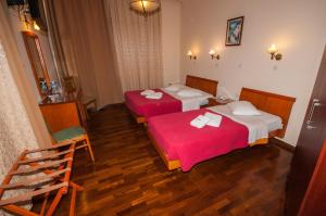 duas camas num quarto de hotel com lençóis vermelhos em Cecil Hotel em Atenas