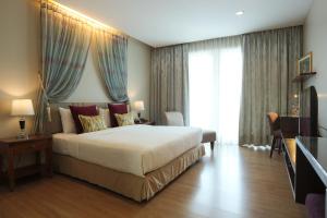 Le Patta Hotel Chiang Rai SHA Extra Plus tesisinde bir odada yatak veya yataklar