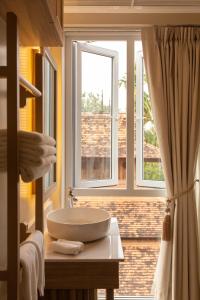 a bathroom with a sink and a window at Nine Hotel Chiangmai in Chiang Mai
