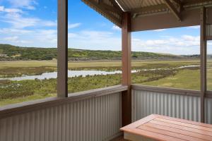 een uitzicht vanaf de veranda van een huis met een tafel bij Otway coastal villas in Princetown