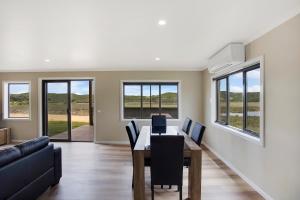 a dining room with a table and chairs and a couch at Otway coastal villas in Princetown