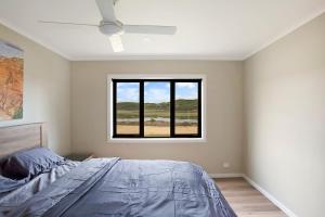 a bedroom with a bed and a window at Otway coastal villas in Princetown