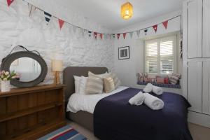 a bedroom with a bed and a mirror and flags at Number One - Nanjivey Row in St Ives