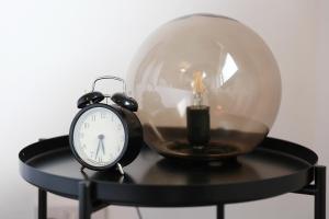 an alarm clock and a glass dome with a candle at Lions Den - Zoo Accommodation Chester in Chester