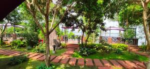 une passerelle dans un parc avec des arbres et des escaliers dans l'établissement Con Khuong Resort Can Tho, à Cần Thơ