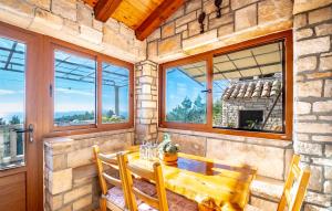 a dining room with a table and chairs and windows at Eco holiday house Cive in Korčula