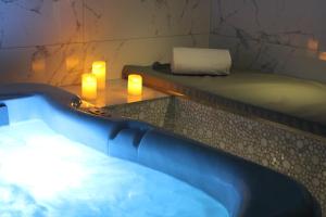 a bath tub with two candles and two lit candles at Secret de Paris - Hotel & Spa in Paris