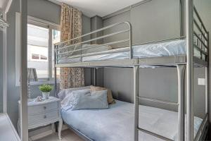 sypialnia z 2 łóżkami piętrowymi i biurkiem w obiekcie Vistas al Mar. Gran Terraza w mieście Calella