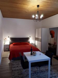 - une chambre avec un lit rouge et une table blanche dans l'établissement Lucky Lady, à Spital am Pyhrn