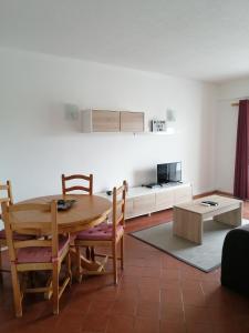 uma cozinha e sala de jantar com mesa e cadeiras em apartamento em albufeira em Albufeira