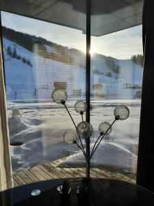 a glass window with a view of a snow covered field at Höss-Alpin-Lodge in Hinterstoder