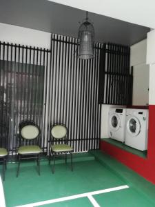 a room with three chairs and a washing machine at B.S. Court Hotel Sathorn in Bangkok