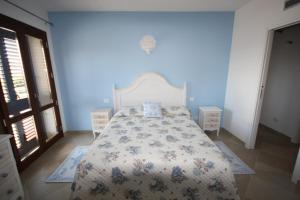 una camera da letto con un letto con copriletto floreale di Le 9 Gocce Seaview Apartment a Palau