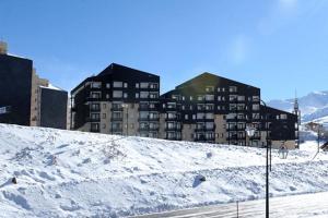 une colline enneigée avec des bâtiments en arrière-plan dans l'établissement 3 Vallées Appartement Mina, aux Menuires