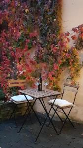 a table and chairs in front of a wall with flowers at Ferienwohnung im Green in Bad Neuenahr-Ahrweiler