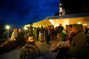 un grupo de personas de pie fuera de un edificio por la noche en Landgasthof Zollhaus, en Sachseln