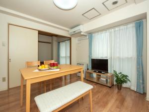 a living room with a table and a television at 札幌市中心部大通公園まで徒歩十分観光移動に便利なロケーションh602 in Sapporo