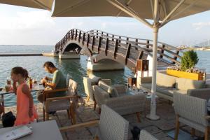 a man and a woman sitting at a table next to a bridge at Square 's House in Lefkada