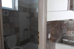 a small bathroom with a toilet and a sink at Square 's House in Lefkada
