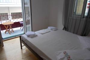 a bed in a room with a view of a balcony at Square 's House in Lefkada