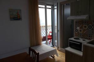 a kitchen with a stove and a door to a balcony at Square 's House in Lefkada