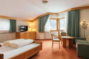 una stanza d'albergo con un letto e una sedia di Hotel Weisseespitze a Kaunertal