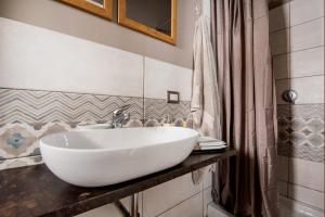 a bathroom with a white sink and a shower curtain at La scala verde in Ragusa