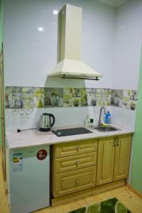 a kitchen with a white refrigerator and a sink at Apartments Provence in Chernivtsi