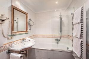 a bathroom with a sink and a bath tub at Appartement Sport Steger in Saalbach Hinterglemm