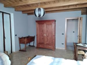 1 dormitorio con 1 cama y armario de madera en Ciabot Besimauda en Peveragno