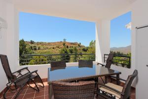 d'une salle à manger avec une table et des chaises sur un balcon. dans l'établissement Vista Alhaurin Golf, à Alhaurín el Grande