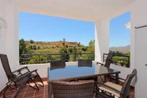 a dining room with a table and chairs on a balcony at Vista Alhaurin Golf in Alhaurín el Grande