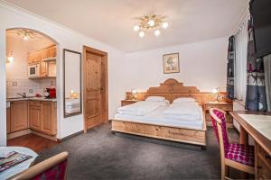 a bedroom with a large bed and a kitchen at Appartement Sport Steger in Saalbach-Hinterglemm