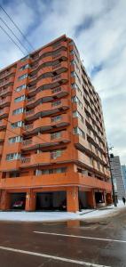 un gran edificio naranja al lado de una calle en 札幌市中心部大通公園まで徒歩十分観光移動に便利なロケーションs1111 en Sapporo